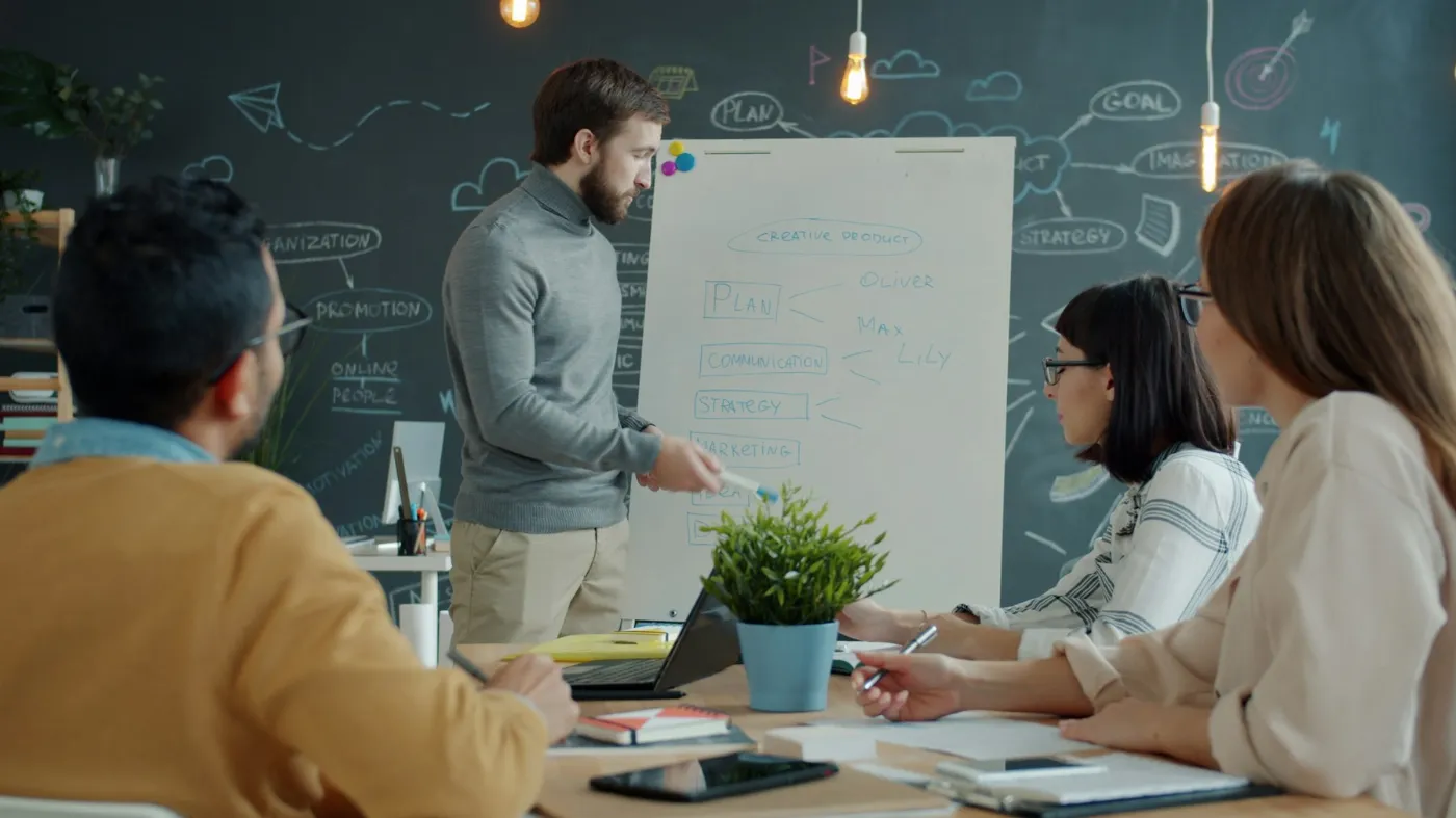 Team planning a project on a whiteboard in a creative office